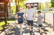 © Louis-Paul Photo - A father and two childs exercising and jogging together at an outdoor park having great fun