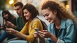 © vefimov - A group of young people are sitting on a bench and looking at their cell phones. They are all smiling and seem to be enjoying themselves