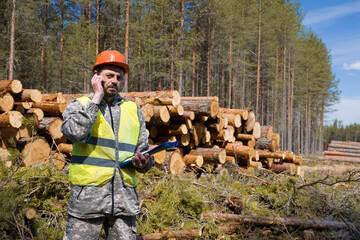 Wall Mural - Forest engineer working in the forest with a satellite phone. Forestry engineer.