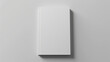 © Michael - Top view of a closed book with a plain white cover on a soft gray background