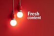 © Michael - Two hanging lights against a red backdrop with the words 'fresh content'