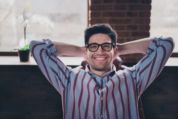 Canvas Print - Photo of nice young corporate man hands behind head wear striped shirt loft interior office indoors