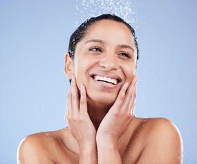 Poster - Face, shower and thinking with woman in studio isolated on blue background for skincare. Beauty, idea or natural hygiene and happy model washing with water for dermatology, hydration or wellness