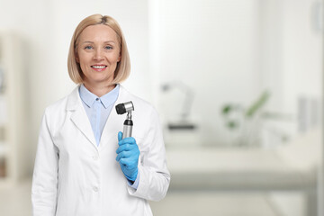 Poster - Professional dermatologist with dermatoscope on blurred background, space for text