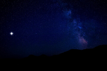 Wall Mural - Sky with twinkling stars over mountains at night