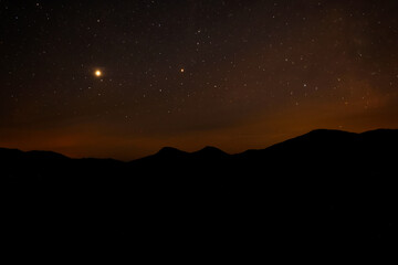 Wall Mural - Sky with twinkling stars over mountains at night