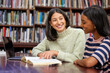 © peopleimages.com - Student, tutor and university library with books or help for education learning, teamwork or scholarship. Female people, brainstorming and course project or research development, college or reading