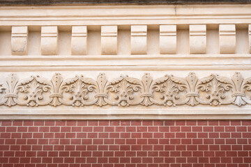 Vintage ornaments on brick facade. Classic frieze on restored old building.