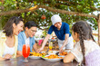 © CandyRetriever  - Happy Asian family parents and child kids having lunch together at beach restaurant while travel at tropical island on summer holiday vacation. Waitress serving food and drink to customer on the table
