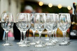 © Микола Бордужак - empty wine glasses stand in a row on the table. blurred background. A garland shines in the background