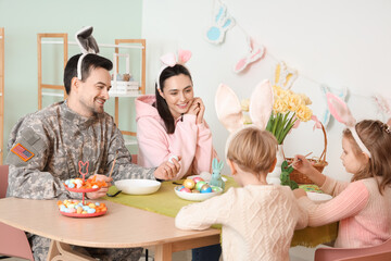 Wall Mural - Male soldier with his family painting Easter eggs at home
