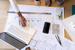 © Wavebreak Media - Diverse team working on architectural plans at desk with various tools
