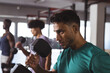 © Wavebreak Media - At gym, diverse men lifting dumbbells, looking focused and fit in gym background