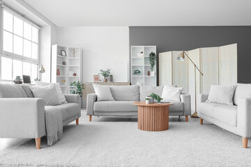 Wall Mural - Interior of living room with grey sofas, table and shelf units