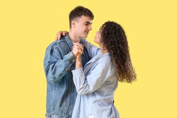 Poster - Young couple in love hugging on yellow background