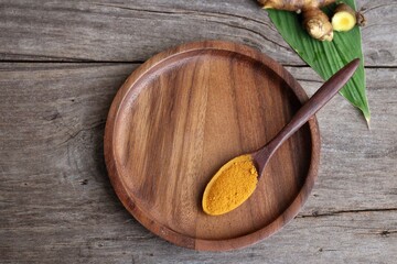 Wall Mural - Turmeric root powder on wood background