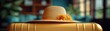© Autaporn - Straw hat with flowers on top of a yellow suitcase, symbolizing travel and summer vacations. Indoor background with blurred elements.