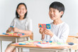 © buritora - 学校の教室でアルファベットのおもちゃを使って英語を勉強する小学生の男の子（低学年）