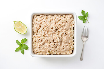 Wall Mural - Top view of creamy chicken salad in white bowl with lemon and parsley on white background.