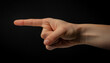 © LADALIDI - a man hand with the index finger pointing outward, in black background, direction, instruction, and emphasis.