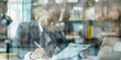 © StockWorld - Focused African American accountant diligently working at a desk in an office, concentrating on documents and a laptop screen.