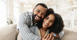 © peopleimages.com - Couple, portrait and hug or relax on couch for date night or weekend break, romance and happiness with love or commitment. Man, woman and bonding on sofa in new apartment or home, affection and care.