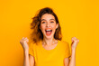 © BetterPhoto - A woman in a yellow shirt is smiling and raising her hands in the air