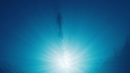 Sticker - Woman swims on the surface of the tropical sea. Bottom underwater view of the young woman swimming in the sea at sunny day