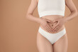 © New Africa - Gynecology. Woman in underwear making heart with her hands on beige background, closeup. Space for text