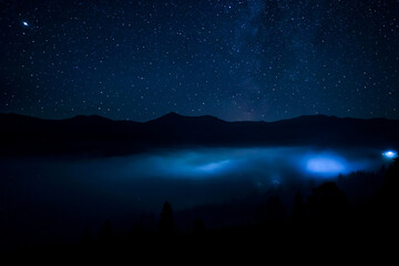 Wall Mural - Sky with twinkling stars over mountains at night