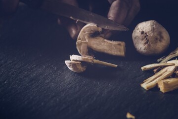 Wall Mural - Person using a knife to cut mushrooms