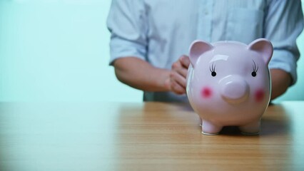 Wall Mural - Man hand putting coins into the piggy bank