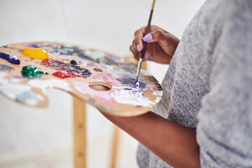 Hands, painting and palette with artistic person closeup in studio for creative expression or learning. Art class, color and oil paint with painter in home or workshop for creativity, or hobby