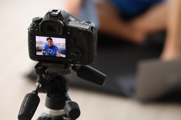 Poster - Smiling sports blogger recording fitness lesson at home, focus on camera. Space for text