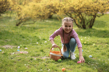 Canvas Print - Easter celebration. Cute little girl hunting eggs outdoors, space for text