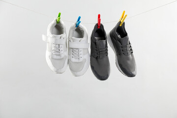 Wall Mural - Different stylish sneakers drying on washing line against light grey background