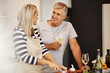 © peopleimages.com - Mature, cooking or happy couple with love, wine or romance in marriage in house, home or kitchen. Talking, romantic man or woman in conversation for bonding together in retirement in meal preparation