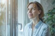 © ChaoticMind - Smiling woman in a blue shirt looking out a window, with a peaceful expression and indoor greenery
