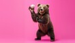 © ZeNDaY - A large brown bear is standing on its hind legs and holding a baseball in its paws. The bear is smiling and looks like it is about to throw the baseball. The background is pink.