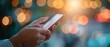© Naret - Close-up of hands holding a smartphone with a bokeh background, capturing the essence of modern digital communication.