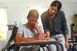 © peopleimages.com - Sad, education and teacher help student in classroom for learning, check assignment and lesson. High school, academy and educator explain question to stressed boy for teaching, studying or assessment
