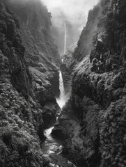 Wall Mural - A black and white photo of a waterfall in a canyon. Concept of awe and wonder at the natural beauty of the waterfall and the surrounding landscape. The contrast between the dark