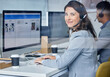 © peopleimages.com - Woman, portrait and call center in office with computer, headset and team for communication with screen. Operator, telemarketing and consultant with customer service for tech support, smile and crm.