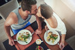 © peopleimages.com - Love, romance and couple with breakfast, kiss and happy morning together in hotel room for honeymoon date. Passion, bonding and man at table with woman, healthy food and coffee at home from above
