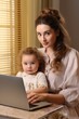 © vefimov - A woman and a child are sitting at a table with a laptop. Concept of bonding and learning