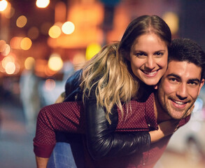 Wall Mural - Couple, portrait and piggyback in city for happy date with bokeh lights at night, romance or bonding. Man, woman and face or downtown New York for anniversary connection with fun, outdoor or love