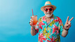© Michael - Elderly man in summer outfit happily poses with a cocktail and peace sign against a blue backdrop