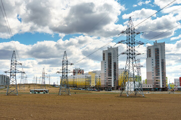 Wall Mural - Power lines in an agricultural field. The support of an overhead power line in a wheat field against the background of clouds.