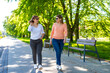 © Jacek Chabraszewski - Two mid-adult beautiful women walking and talking in city park