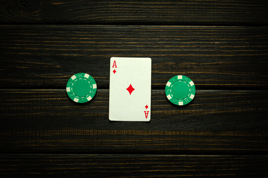 Ace of diamonds is good luck in the game of poker. Playing card and green chips on a dark vintage table in a club